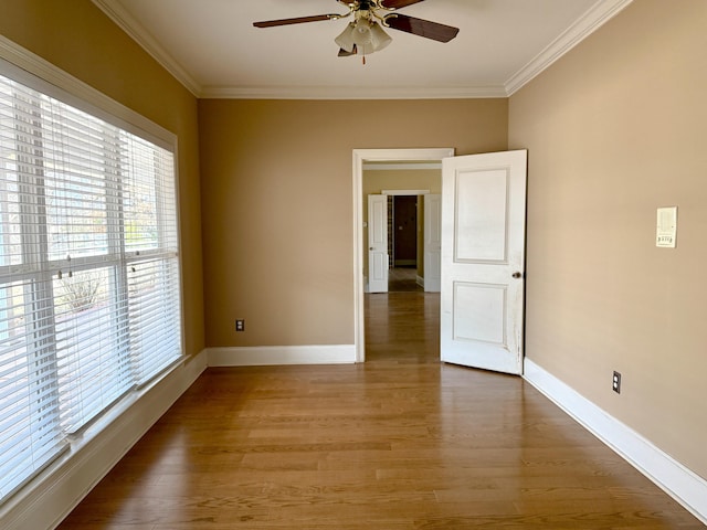 empty room with hardwood / wood-style flooring, ceiling fan, and ornamental molding