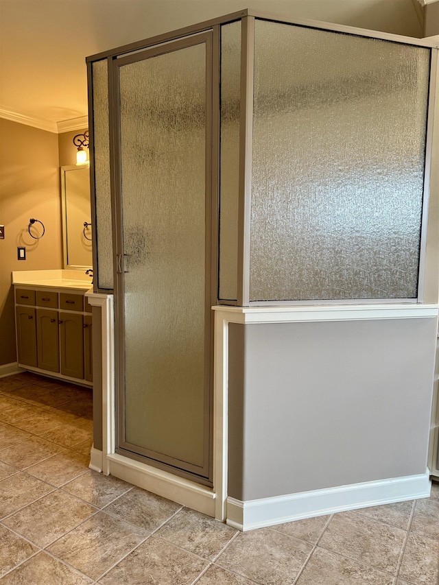 bathroom featuring crown molding, vanity, a shower with shower door, and tile patterned flooring