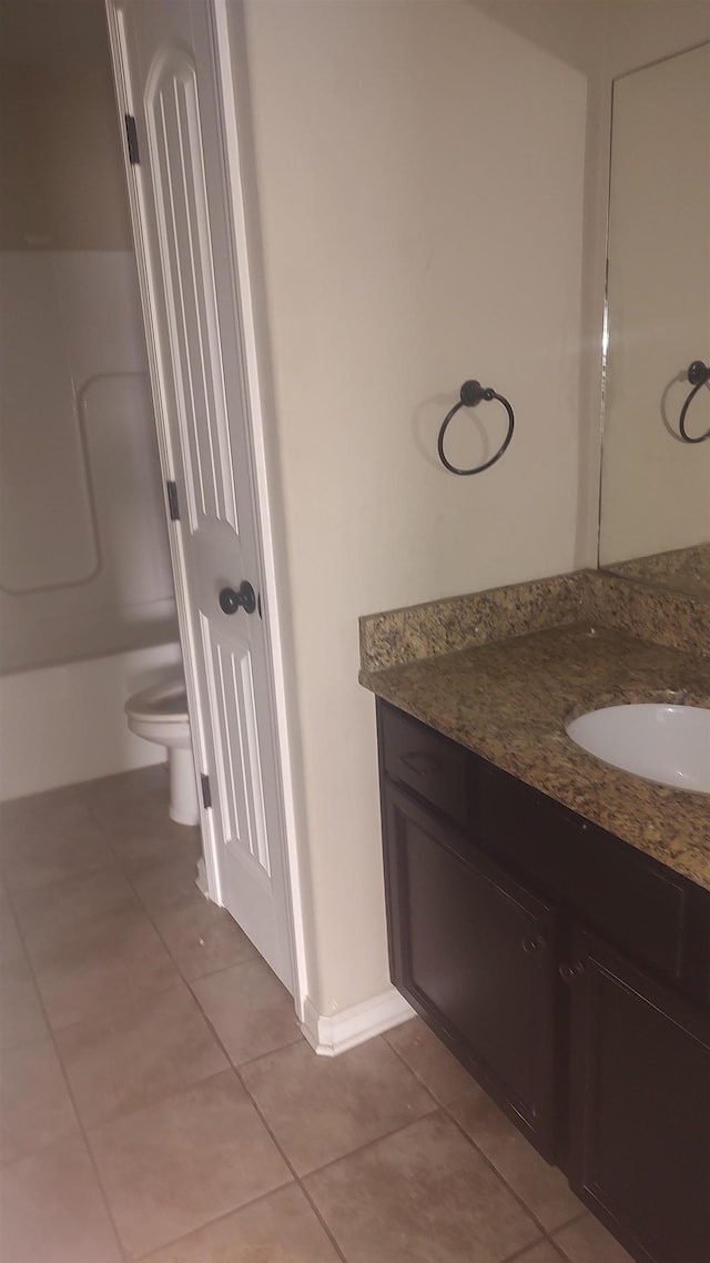 full bathroom with toilet, vanity, and tile patterned floors