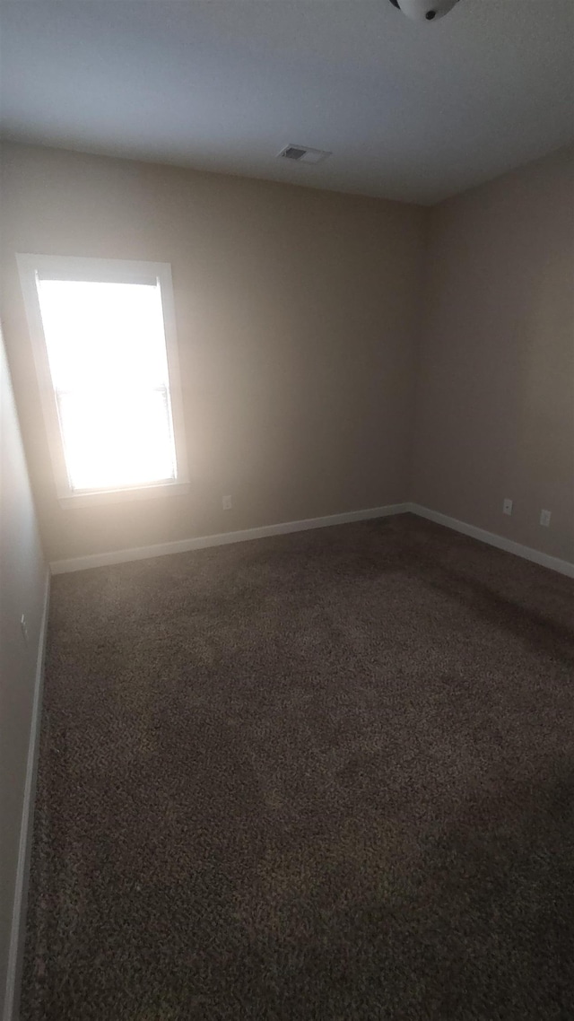 carpeted empty room featuring visible vents and baseboards