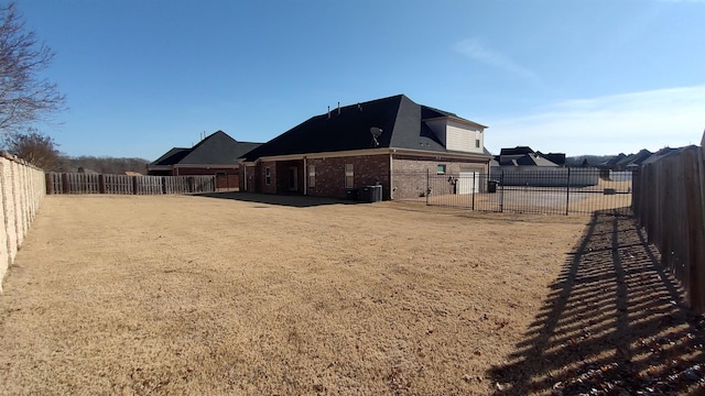 view of yard with a fenced backyard and central AC