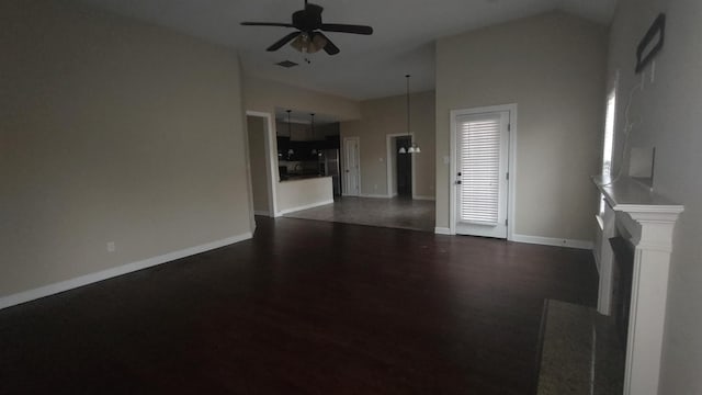 unfurnished living room with baseboards, lofted ceiling, dark wood-style floors, ceiling fan, and a fireplace