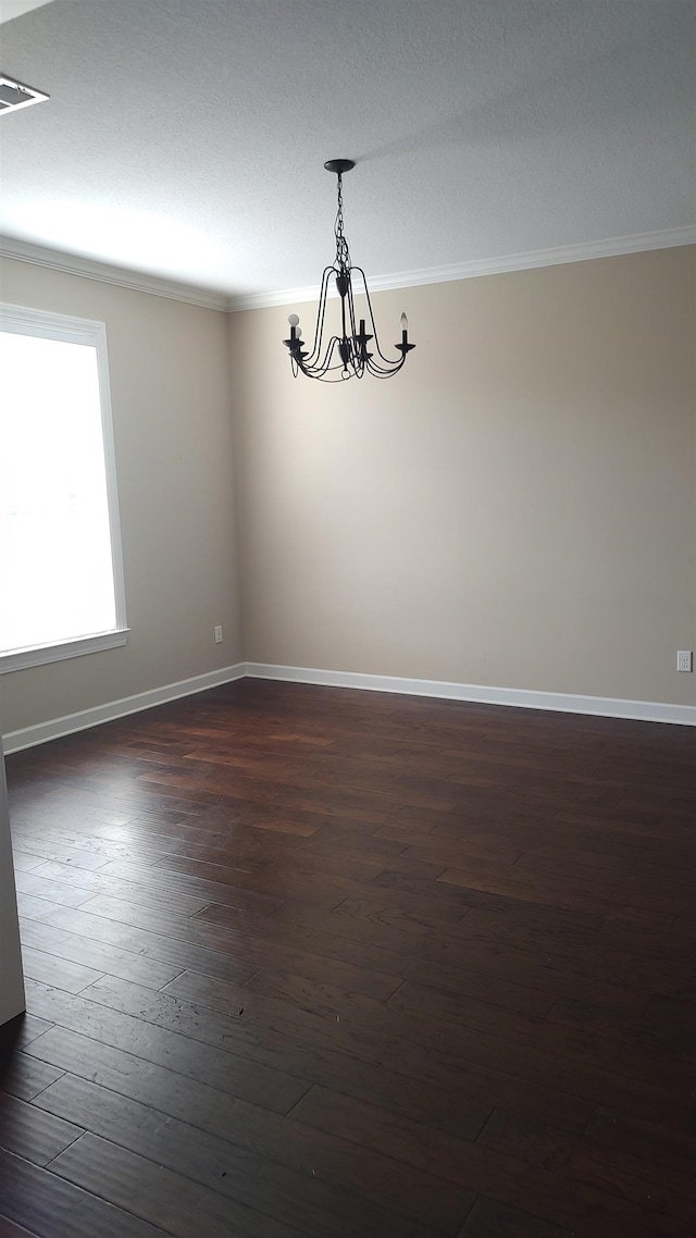 unfurnished room featuring ornamental molding, dark hardwood / wood-style floors, and an inviting chandelier