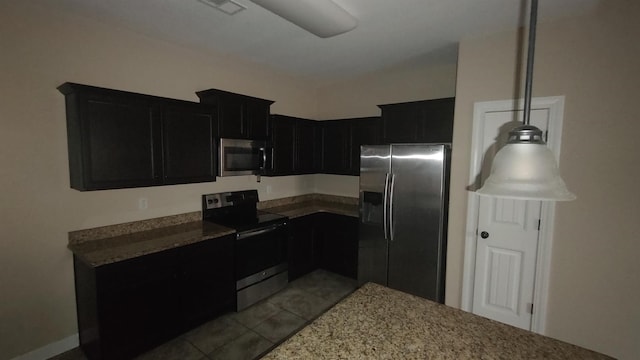 kitchen featuring visible vents, light stone counters, dark cabinets, stainless steel appliances, and light tile patterned flooring