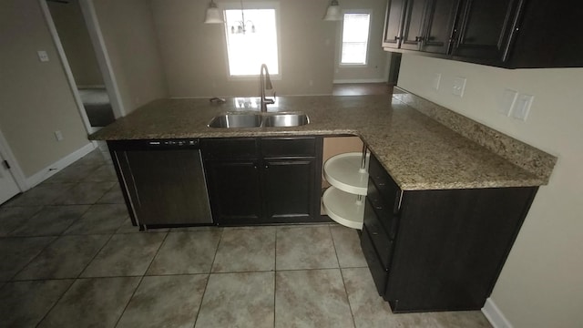 kitchen with dark cabinetry, a sink, and stainless steel dishwasher