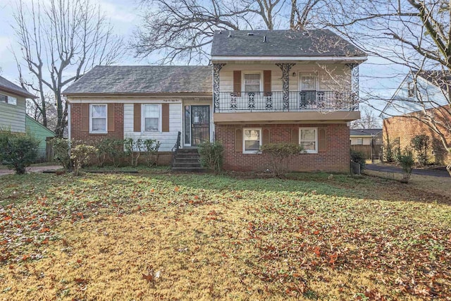 view of front of home featuring a balcony and a front yard