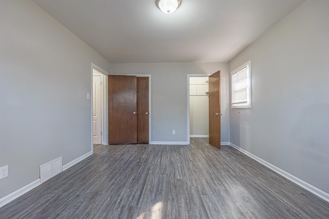 unfurnished bedroom featuring dark wood-type flooring and a closet