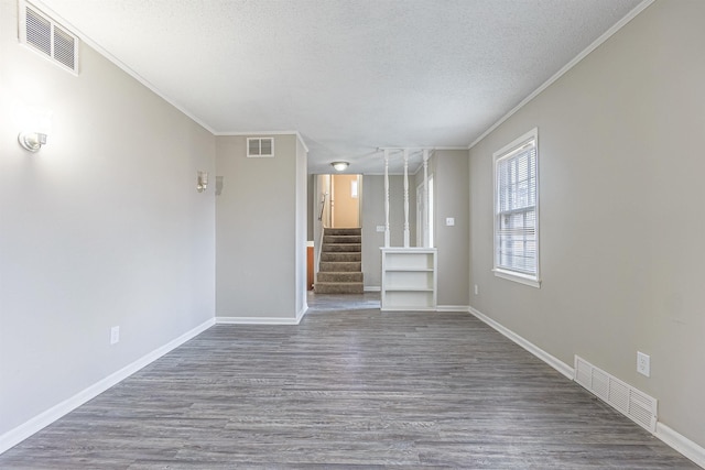 unfurnished living room with ornamental molding, dark hardwood / wood-style floors, and a textured ceiling