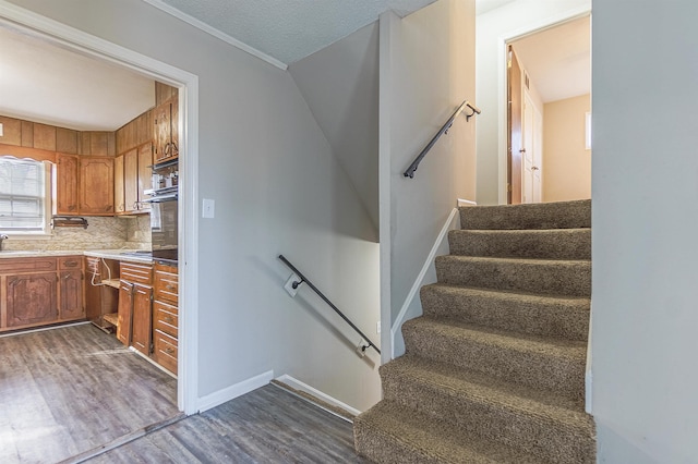 stairway with wood-type flooring and sink