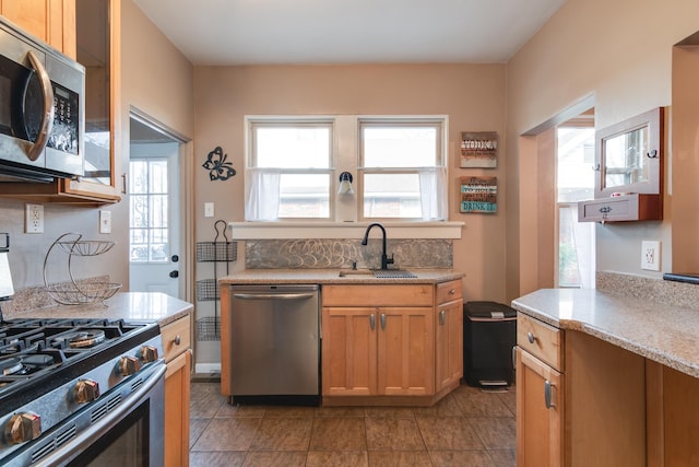 kitchen with appliances with stainless steel finishes, sink, and light tile patterned floors