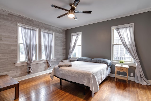 bedroom with hardwood / wood-style flooring, ceiling fan, and crown molding