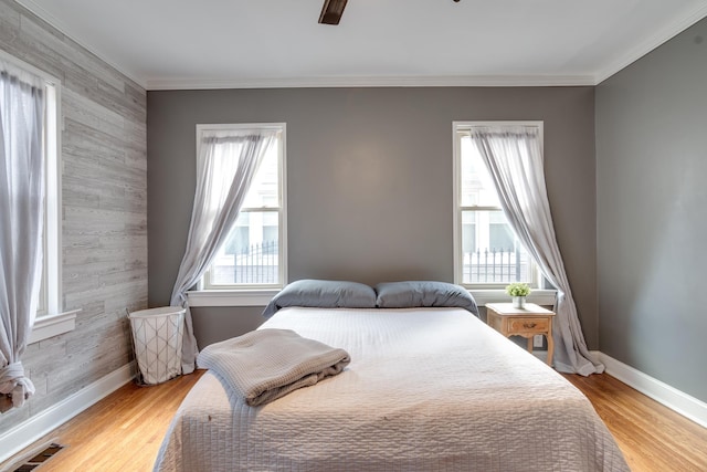 bedroom with crown molding, ceiling fan, and light hardwood / wood-style flooring