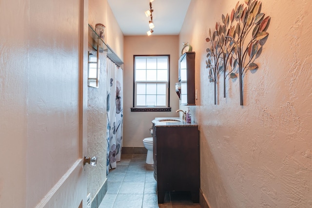 bathroom with vanity, track lighting, tile patterned floors, and toilet