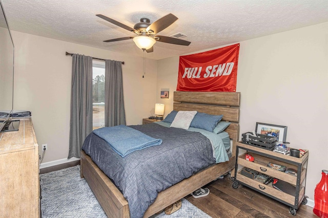 bedroom featuring ceiling fan, dark hardwood / wood-style floors, and a textured ceiling