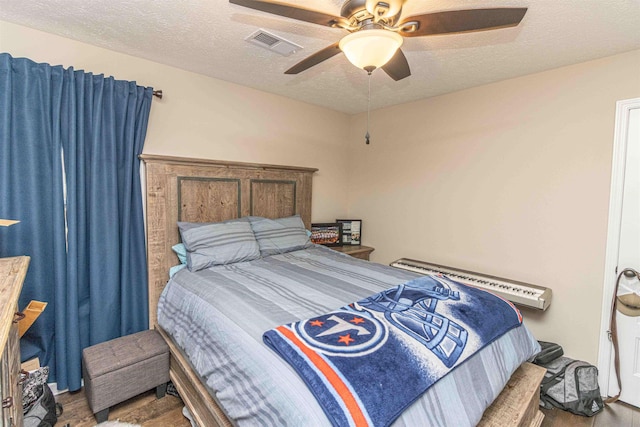 bedroom with ceiling fan and a textured ceiling