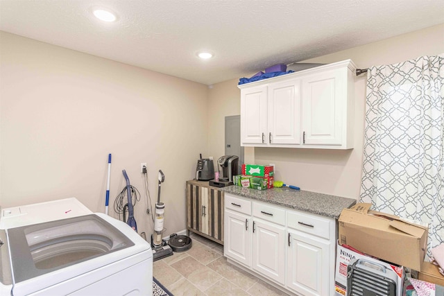 washroom featuring washer / dryer, cabinets, and a textured ceiling