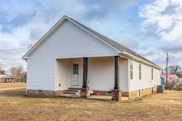 view of front of house with central AC and a front yard