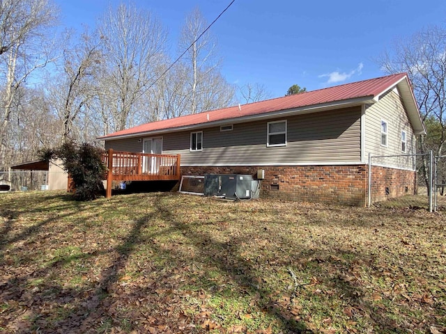 rear view of property featuring a yard, a deck, and central air condition unit