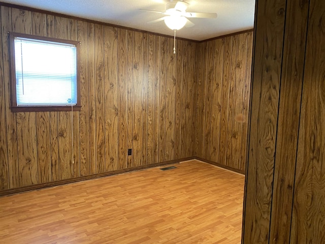 spare room featuring ornamental molding, light hardwood / wood-style floors, and ceiling fan