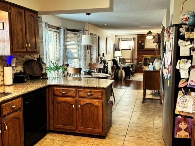 kitchen with light tile patterned floors, stainless steel refrigerator, black dishwasher, and ceiling fan