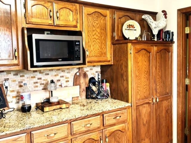 kitchen with light stone countertops and decorative backsplash