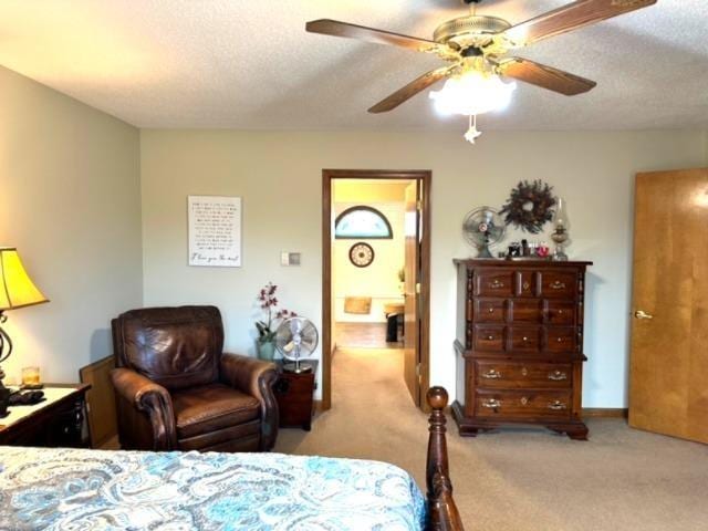 carpeted bedroom featuring ceiling fan and a textured ceiling