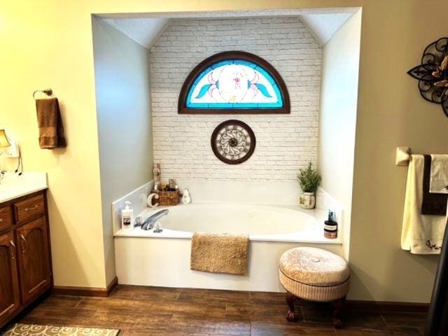 bathroom featuring a washtub, vanity, lofted ceiling, and hardwood / wood-style floors