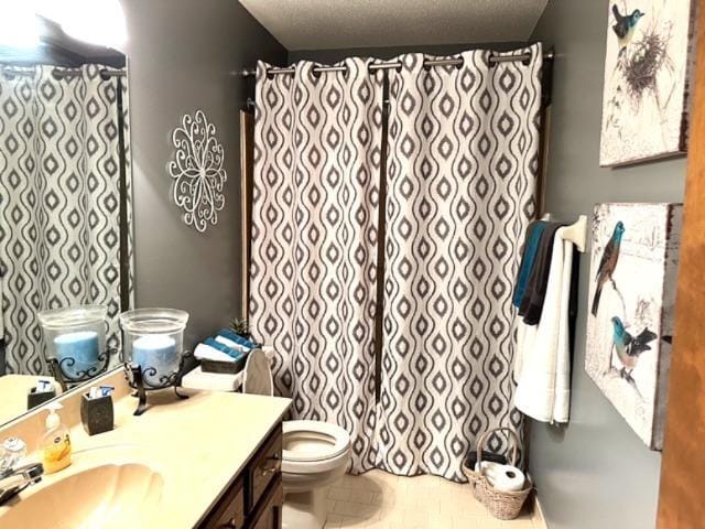 bathroom featuring vanity, a textured ceiling, and toilet