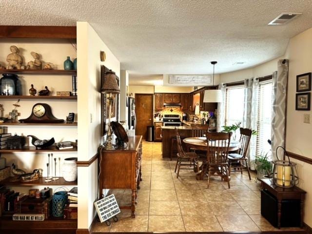 dining area with a textured ceiling and light tile patterned floors