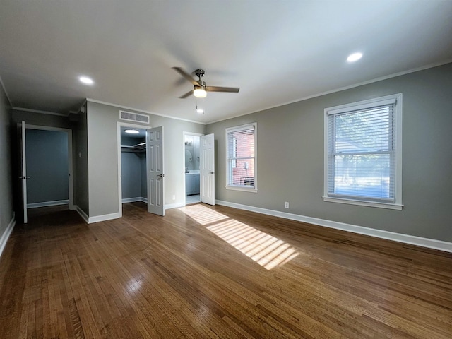 unfurnished bedroom with crown molding, dark wood-type flooring, and a closet