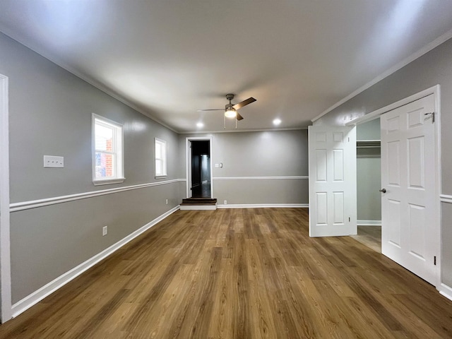 interior space featuring ceiling fan, wood-type flooring, and ornamental molding