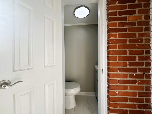 bathroom featuring crown molding and toilet