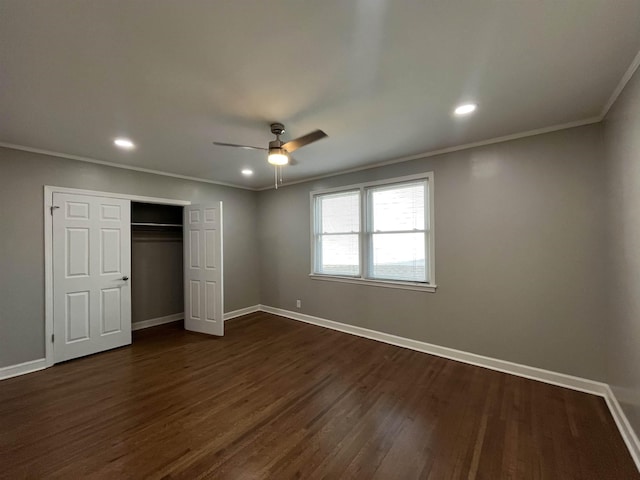 unfurnished bedroom with crown molding, ceiling fan, dark wood-type flooring, and a closet