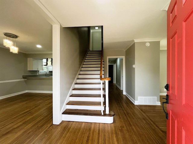 stairs featuring hardwood / wood-style flooring, ornamental molding, and sink