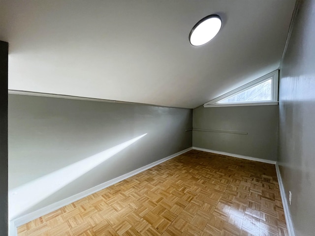 additional living space with light parquet flooring and vaulted ceiling