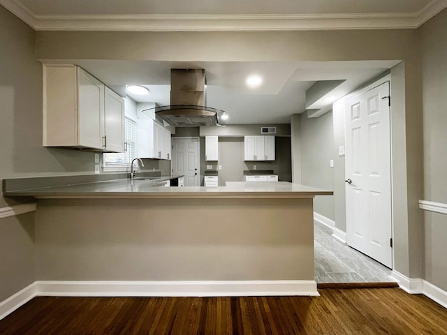 kitchen with sink, white cabinetry, kitchen peninsula, island exhaust hood, and light hardwood / wood-style floors