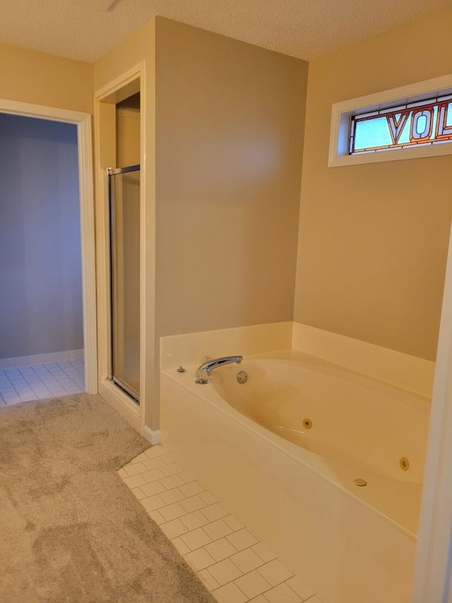 bathroom with tile patterned floors, plus walk in shower, and a textured ceiling