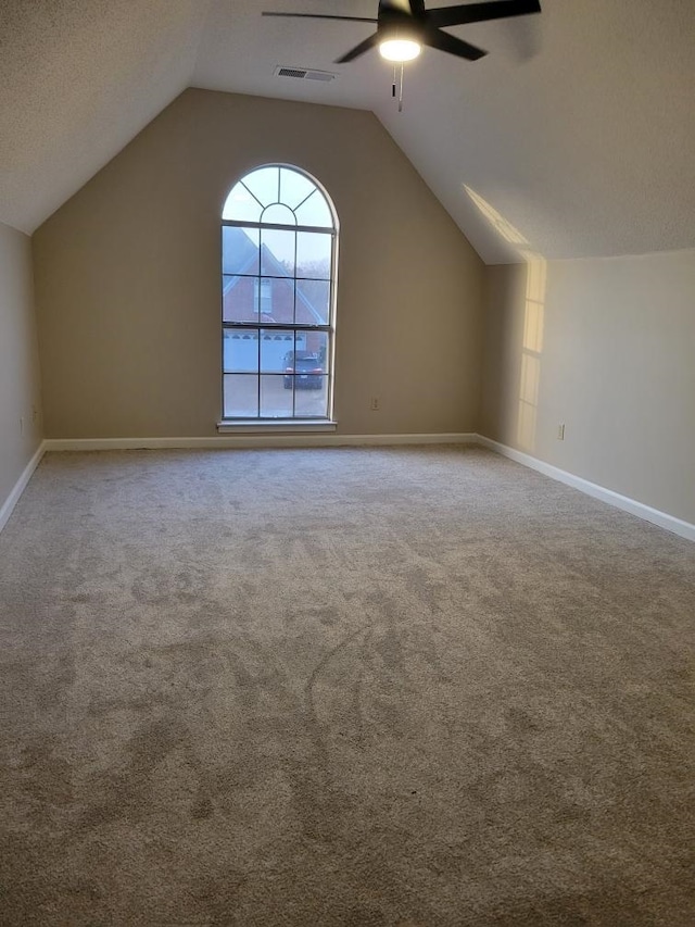 additional living space featuring ceiling fan, lofted ceiling, carpet floors, and a textured ceiling