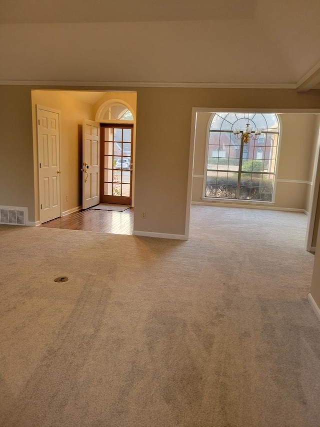 carpeted spare room with plenty of natural light and ornamental molding