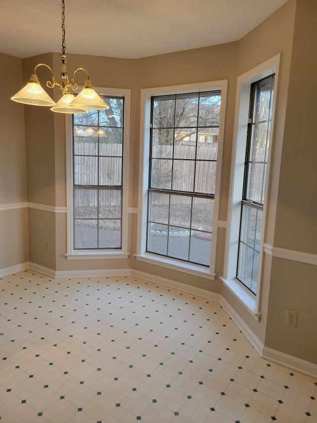 unfurnished dining area featuring a chandelier