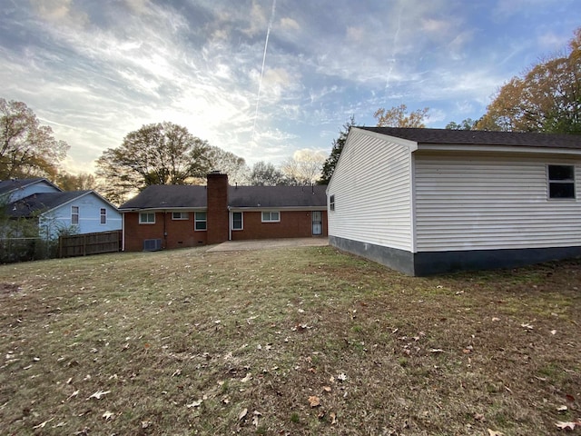 view of side of property with a lawn and central air condition unit