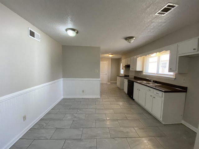 kitchen featuring white cabinetry, sink, and black dishwasher