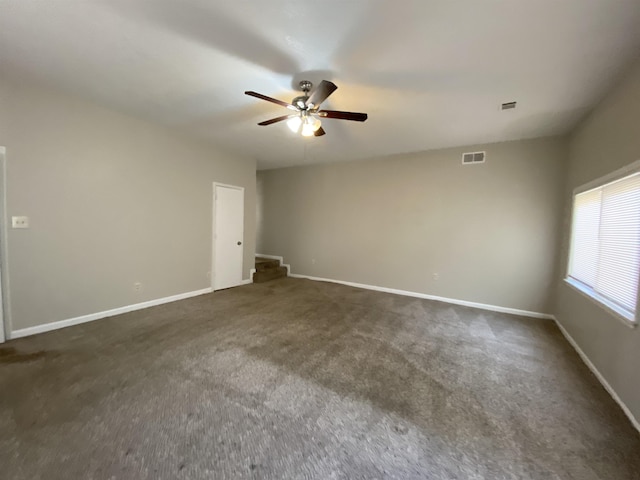 spare room with dark carpet and ceiling fan