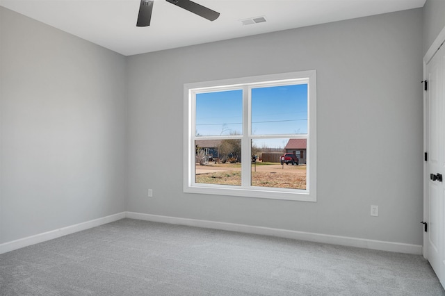 unfurnished room with ceiling fan and carpet