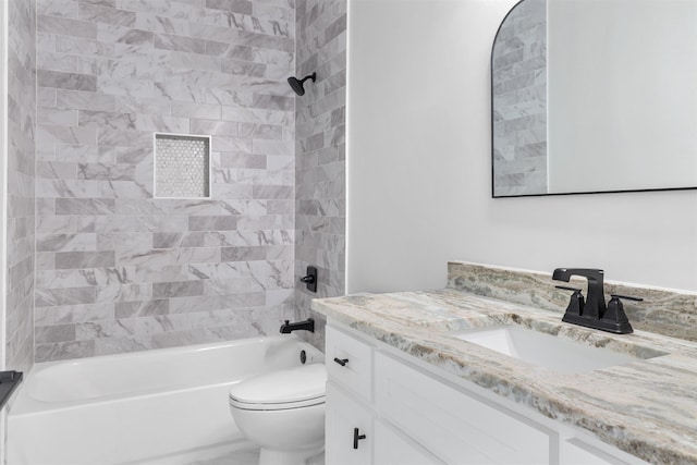 full bathroom with vanity, tiled shower / bath combo, and toilet