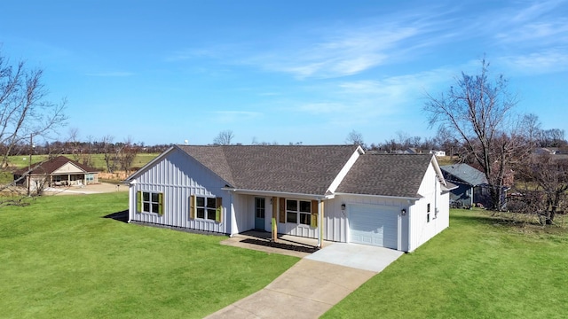 view of front of house with a garage, covered porch, and a front lawn