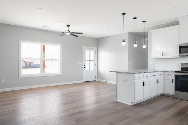 kitchen with hanging light fixtures, appliances with stainless steel finishes, hardwood / wood-style flooring, and white cabinets