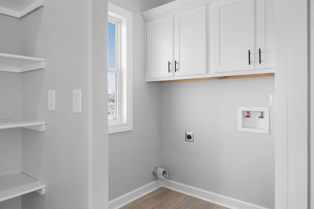 clothes washing area featuring hookup for a washing machine, electric dryer hookup, cabinets, and light hardwood / wood-style flooring