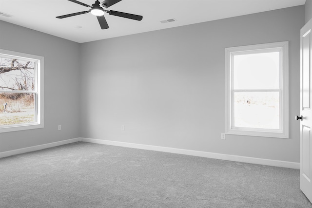 carpeted spare room featuring ceiling fan