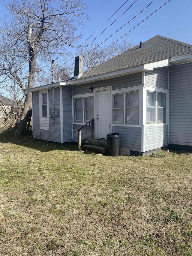 rear view of house featuring a lawn